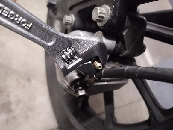 Bajamos a la pinza de freno y buscamos el pitorro para purgar, suele ir tapado con un capuchón de goma Bajamos a la pinza de freno y buscamos el pitorro para purgar, suele ir tapado con un capuchón de goma
